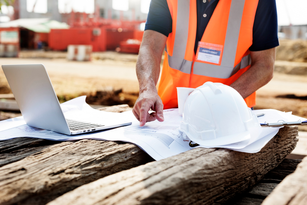 Image of construction manager onsite with a laptop