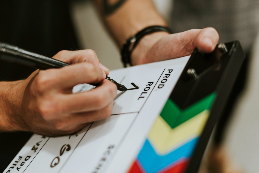 Image of director writing on clapper board to depict Film Studies course