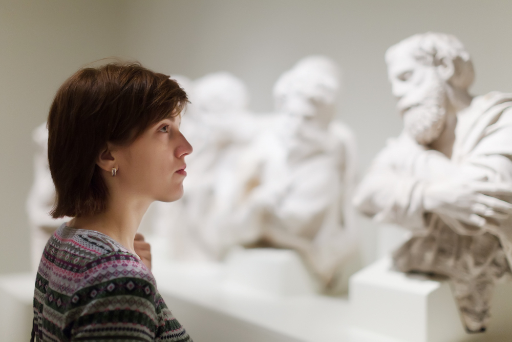 Image of woman in front of statues. 