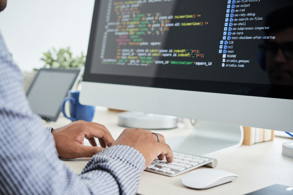 Image of man at a computer writing code