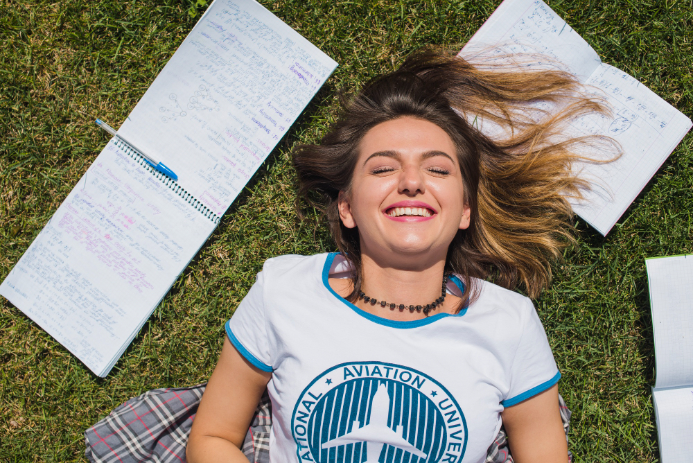 Image of a happy student in summer with their study notes