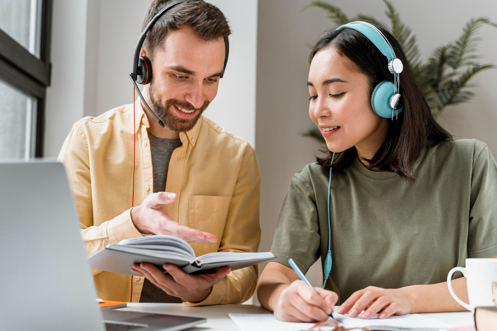 Image of two students with headphones translating. 
