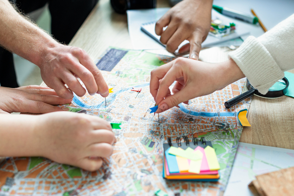 Image of urban planners around a map with pins and post-it notes. 